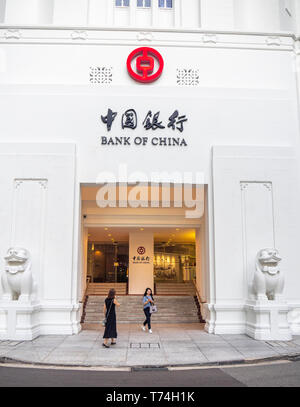 Zwei Frauen, die vor dem Eingang der Bank von China Gebäude in der Innenstadt von Singapur. Stockfoto