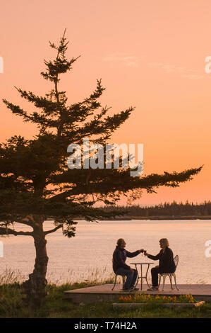 Paar entspannende entlang der atlantischen Küste bei Sonnenuntergang, Bucht von Fundy; Blanche, Nova Scotia, Kanada Stockfoto