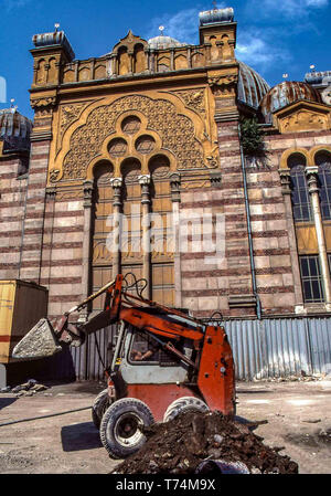 Sofia, Bulgarien. 2. Aug 1991. Eine kleine Planierraupe bei der Arbeit vor der Venezianischen Architektur im Stil der Fassade des byzantinischen und Spanisch-maurischen Grand sephardische Synagoge, im Herzen von Sofia, der Hauptstadt Bulgariens. Während des Zweiten Weltkriegs beschädigt, es nie erhalten keine Wiederherstellung unter dem kommunistischen Regime. Die Arbeiten begannen im Jahre 1991, mit Israelischen spenden, die historische Struktur zu rehabilitieren, eine touristische Attraktion. Credit: Arnold Drapkin/ZUMA Draht/Alamy leben Nachrichten Stockfoto