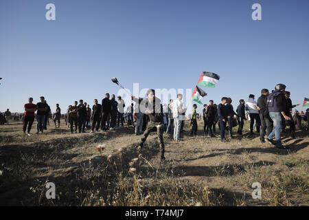 Gaza, Gaza, Gaza. 3. Mai, 2019. Einen palästinensischen Demonstrant mit einer Schleuder Steine auf israelische Truppen während der Zusammenstöße auf der Gaza-Israel Grenze zu schleudern, östlich von Gaza-stadt gesehen. Mindestens 50 Palästinenser bei Auseinandersetzungen zwischen Demonstranten, die die wöchentliche anti-Israel Proteste und israelische Soldaten an der Grenze zwischen dem Osten Gazastreifen und Israel stationiert waren verletzt worden, sagte der Mediziner. Credit: nidal Alwaheidi/SOPA Images/ZUMA Draht/Alamy leben Nachrichten Stockfoto