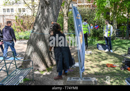 Brighton UK 4. Mai 2019 - Schauspieler bereitet sich hinter einem Schirm vor der Durchführung an treets das Brighton Festival Fringe von Brighton" Veranstaltung im Zentrum der Stadt am Eröffnungstag. Foto: Simon Dack/Alamy leben Nachrichten Stockfoto