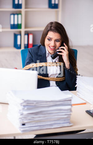 Junge schöne Mitarbeiter gebunden mit Seil im Büro Stockfoto