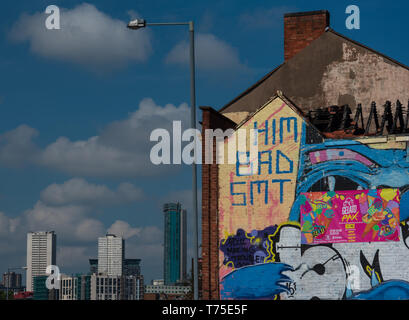 Graffiti auf ausgebrannte Gebäude in Birmingham, England mit modernen Hochhäusern im Hintergrund. Stockfoto