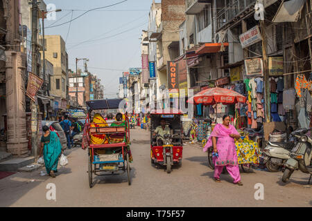 Fahrrad- und Elektro-Rikschas, die Straße in Paharganj, Neu Delhi Stockfoto