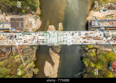 Fliegen über große Autobahn Baustelle mit Kran Stockfoto