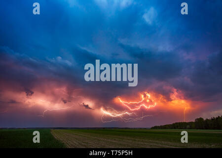 Blitz mit dramatischen Wolken zusammengesetzte Bild. Nacht Gewitter Sturm in Litauen Stockfoto