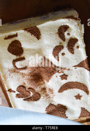 Tiramisu mit Zeichnungen Schablone von Kakao auf einem dunklen Holz- Board eingerichtet Stockfoto