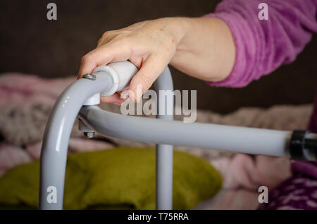 Hände von einer älteren Frau an den Griffen eines Wanderers. Rehabilitation und healthcare Konzept. Stockfoto