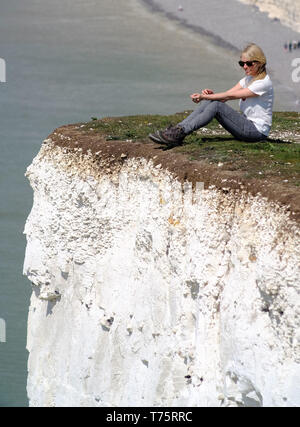 Touristen ihr Leben riskieren selfies auf 400 Fuß bröckelnden Kreidefelsen zu erhalten, Birling Gap, East Sussex, Großbritannien Stockfoto