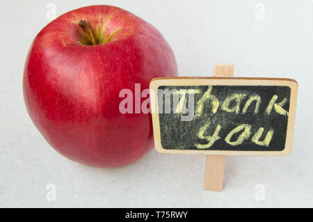 Apple mit vielen Dank Inschrift auf einem Holzbrett schwarzer Hintergrund Stockfoto