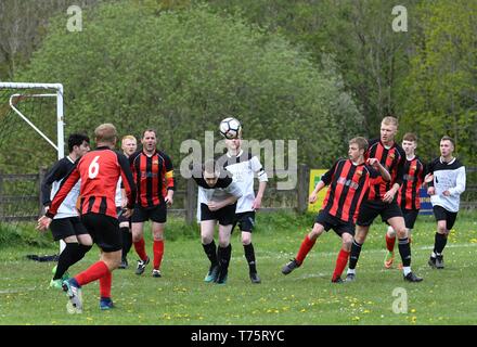Fußball-Aktion in der Hoffnung Tal Amateur Liga Match zwischen Buxworth Reserven (Rot/Schwarz) und beschwipst Kröte (weiß). Stockfoto
