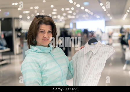 Die Frau entscheidet, Bluse im Store. Stockfoto