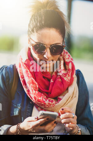 Junge Frau mit Handy im Freien im Frühjahr. Stockfoto