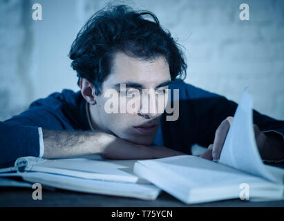 Überarbeitet und müde männliche Kursteilnehmer spät in der Nacht arbeiten am Laptop versuchen nicht zu schlafen Gefühl ermüdet, besorgt und traurig. Moody Dark Light. Endg. Stockfoto