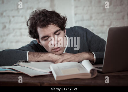 Überarbeitet und müde männliche Kursteilnehmer spät in der Nacht arbeiten am Laptop versuchen nicht zu schlafen Gefühl ermüdet, besorgt und traurig. Moody Dark Light. Endg. Stockfoto