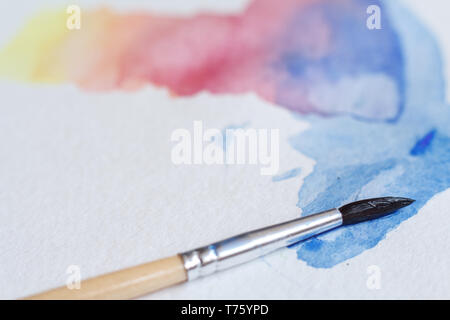 In der Nähe von schönen Aquarell Pinselstrichen auf einem weißen Blatt, einen Pinsel in der Bild, Hintergrund oder Konzept Stockfoto
