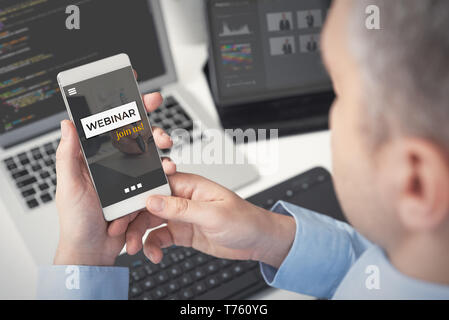 Webinar online, Internet Bildung. Mann beobachten e-learning Inhalte auf dem Smartphone Stockfoto