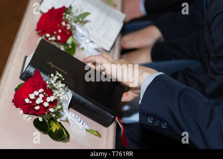 Ein Bild der Heiligen Bibel mit roten Rosen in der Kirche Stockfoto