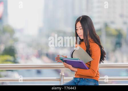 Vielfalt Jugendlicher ein Buch lesen mit unscharfen Hintergrund an der Universität. Stockfoto