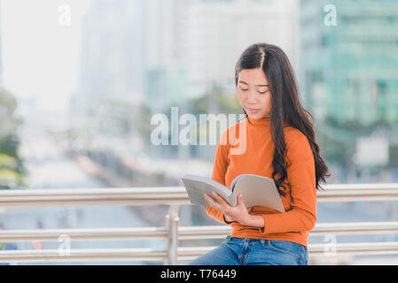 Vielfalt Jugendlicher ein Buch lesen mit unscharfen Hintergrund an der Universität. Stockfoto