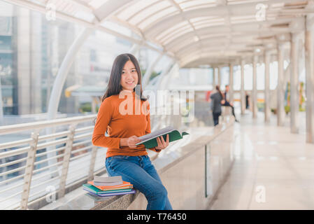 Vielfalt Jugendlicher ein Buch lesen mit unscharfen Hintergrund an der Universität. Stockfoto