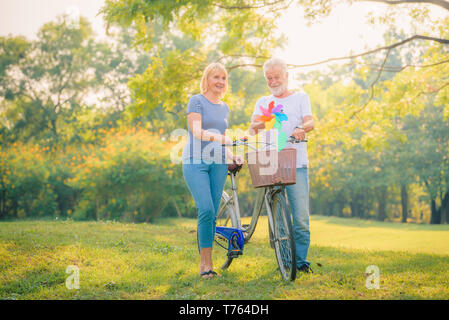 Ältere Paare lesen Zeitung im Garten bei Sonnenuntergang. Konzept paar Elder lieben. Stockfoto