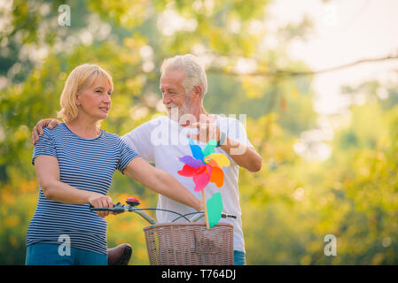 Ältere Paare lesen Zeitung im Garten bei Sonnenuntergang. Konzept paar Elder lieben. Stockfoto