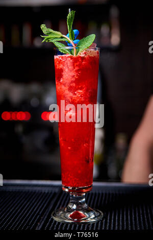 Kalten Fruchtcocktail mit Minze und einem Strohhalm auf der Theke. Stockfoto