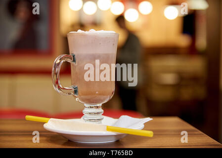 Milchshake mit Strohhalmen auf einem hölzernen Tisch in einem Cafe. Stockfoto