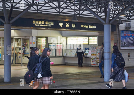 Japanische high school Mädchen und andere Erwachsene Spaziergang rund um den Eingang des Kanto Eisenbahn Joso Linie Moriya Station in Ibaraki, Japan am Abend. Stockfoto