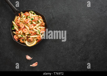 Nudeln mit Garnelen oder Shrimps auf Schwarz, Ansicht von oben, kopieren. Zitrone Nudeln mit Sautierten Garnelen, frische Meeresfrüchte. Stockfoto