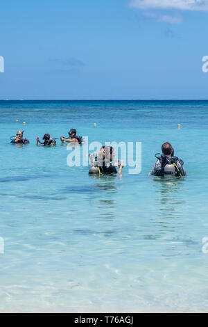 Taucher in voller Tauchausrüstung prpare für einen Tauchgang in West Bay Roatan Honduras. Stockfoto