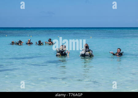 Taucher in voller Tauchausrüstung für einen Tauchgang vor der Küste von West Bay Roatan Honduras vorzubereiten. Stockfoto