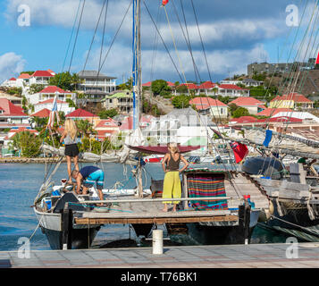 Zwei Frauen und ein Mann, ein Katamaran in den Hafen von Gustavia, St. Barts Stockfoto