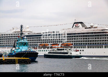 Tug Boat Vivax an tollboden Quay. Im Hintergrund, Kreuzfahrtschiff Viking Meer, skolten Terminal im Hafen von Bergen, Norwegen. Katamaran Ekspressen abfliegen Stockfoto