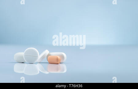 Apotheke Apotheke Produkt. Stapel von Orange und weiße Tabletten Pille auf farbverlauf Hintergrund. Unterschiedliche Größe und Form tabletten Pillen. Pharmazeutische Stockfoto