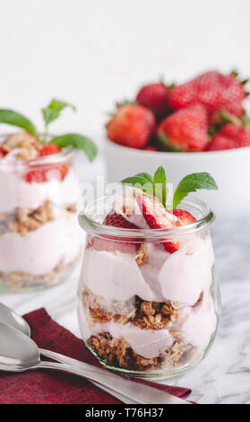 Nahaufnahme von einem Parfait mit Joghurt, Müsli und frischen Erdbeeren im Glas gemacht Stockfoto