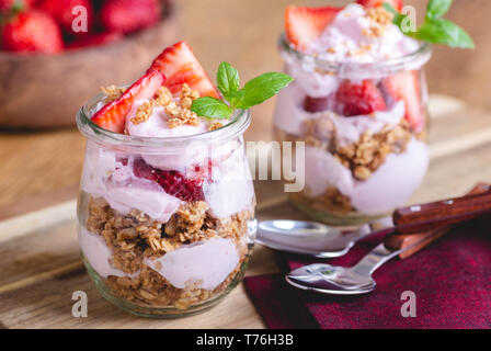 Nahaufnahme von einem Parfait mit Joghurt, Müsli und frischen Erdbeeren im Glas gemacht Stockfoto