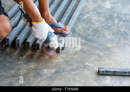Arbeiter Schneiden von Metall mit der Fräse und Funken beim Schleifen Stahl Stockfoto