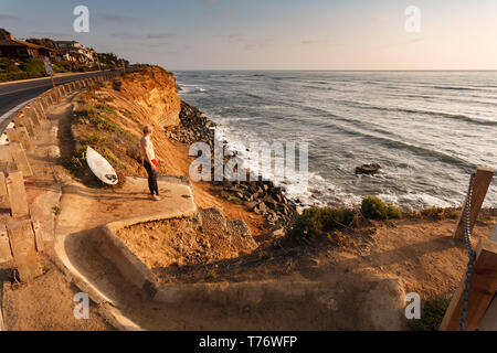 Surfer steht auf einem Felsen über Surf Breaks in San Diego, Kalifornien, zu beobachten Stockfoto