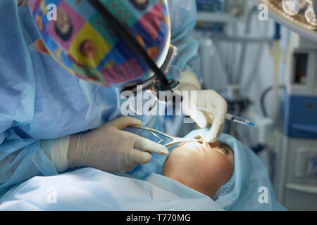 Mehrere Ärzte, die Patienten auf dem OP-Tisch bei ihrer Arbeit. Team Chirurgen bei der Arbeit im Operationssaal. Stockfoto