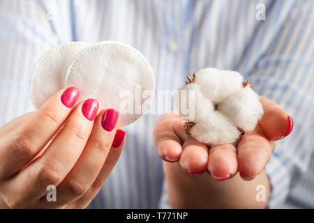 Flauschige Baumwolle ball und Wattestäbchen und Pads in den Händen Stockfoto