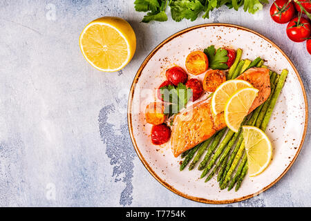 Gegrillter Lachs mit Spargel und Tomaten, Ansicht von oben. Stockfoto