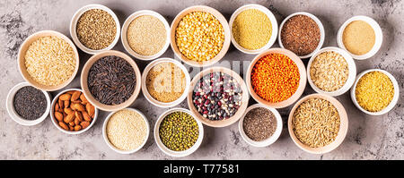Satz von verschiedenen Superfoods - ganze Körner, Bohnen und Hülsenfrüchte, Samen und Nüsse, Ansicht von oben. Stockfoto