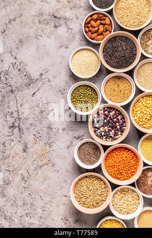 Satz von verschiedenen Superfoods - ganze Körner, Bohnen und Hülsenfrüchte, Samen und Nüsse, Ansicht von oben. Stockfoto