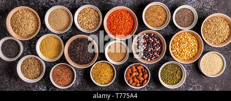 Satz von verschiedenen Superfoods - ganze Körner, Bohnen und Hülsenfrüchte, Samen und Nüsse, Ansicht von oben. Stockfoto