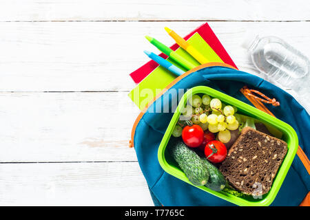 Zurück zum Konzept der Schule. Lunch Box mit Schreibwaren und Rucksack. Stockfoto