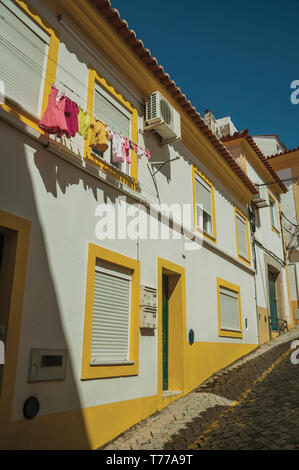 Alten bunten Reihenhaus mit Kleidung aufhängen an Fenster Trocknung in einer Gasse von Portalegre. Eine kleine Stadt in der Nähe von mamede Bergkette in Portugal. Stockfoto