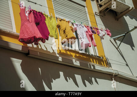 Nahaufnahme der Kleidung hängen an Fenster Trocknen im bunten Haus in einer Gasse von Portalegre. Eine kleine Stadt in der Nähe von mamede Bergkette in Portugal. Stockfoto