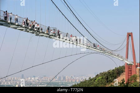 Wuxi in der chinesischen Provinz Jiangsu. 4. Mai, 2019. Touristen zu Fuß über eine gläserne Brücke an der International World Adventure Park in Huaxi Dorf Jiangyin city, der ostchinesischen Provinz Jiangsu, 4. Mai 2019. Die 518 Meter lange Brücke aus Glas mehr als 100 Meter über dem Boden im Park hängt. Es ist für Scheiben aus 35 mm dicken Glas. Jedes Glas kann ein maximales Gewicht von 4,7 Tonnen. Rund 2.600 Personen können die Brücke zu einem Zeitpunkt kreuzen. Credit: Xu Congjun/Xinhua/Alamy leben Nachrichten Stockfoto